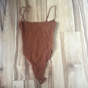 SKIMS bodysuit, size xxs, color is sort of like a brownish orange rust color